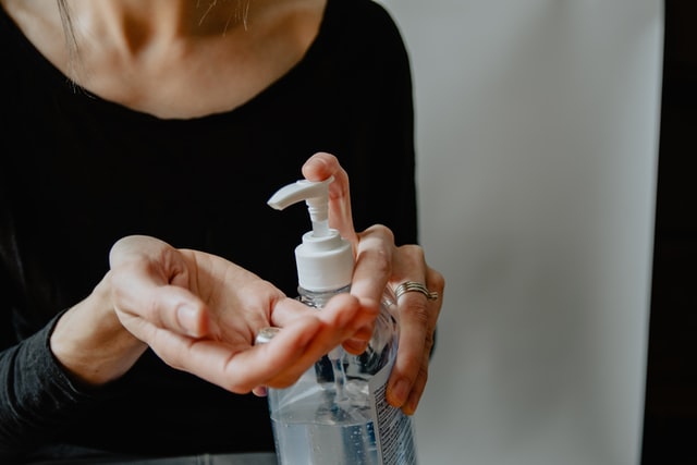Woman cleaning her hands with hand sanitizer