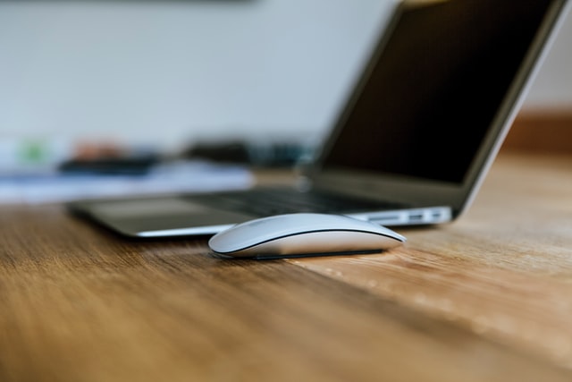 Laptop and computer mouse on a desk