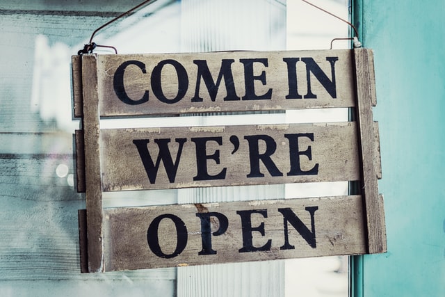 "Open" sign hanging on a wall.